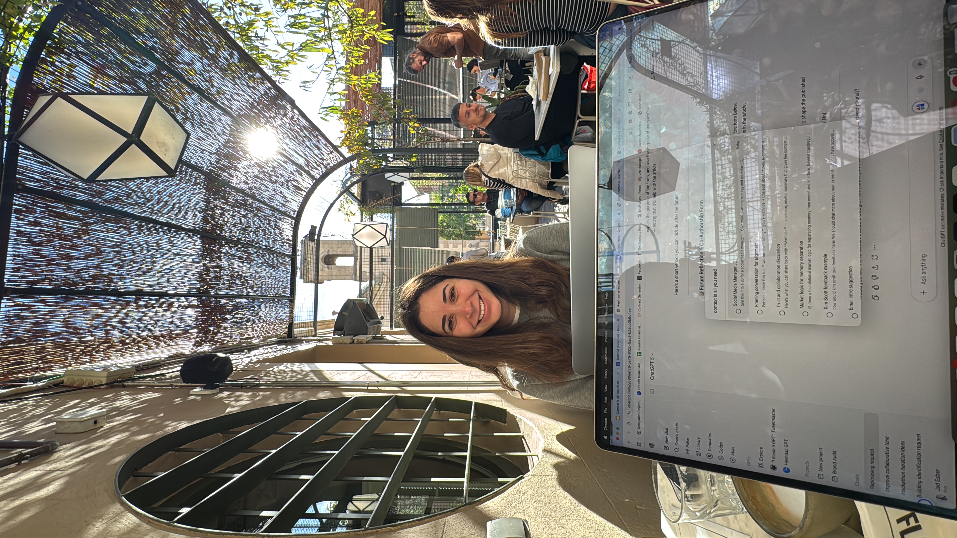 Reem at a rooftop cafe with laptop